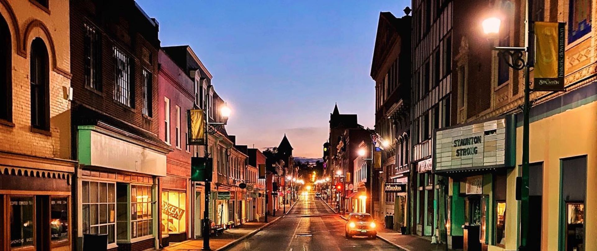 Shops along downtown Staunton streets are glowing in the evening dusk. 