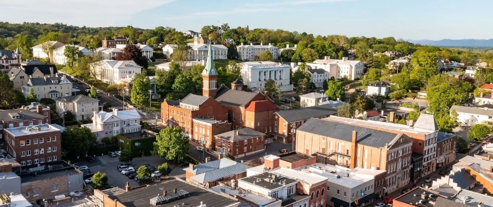 An aerial view of a church with a tall steeple and surrounding buildings in Staunton  Virginia. 