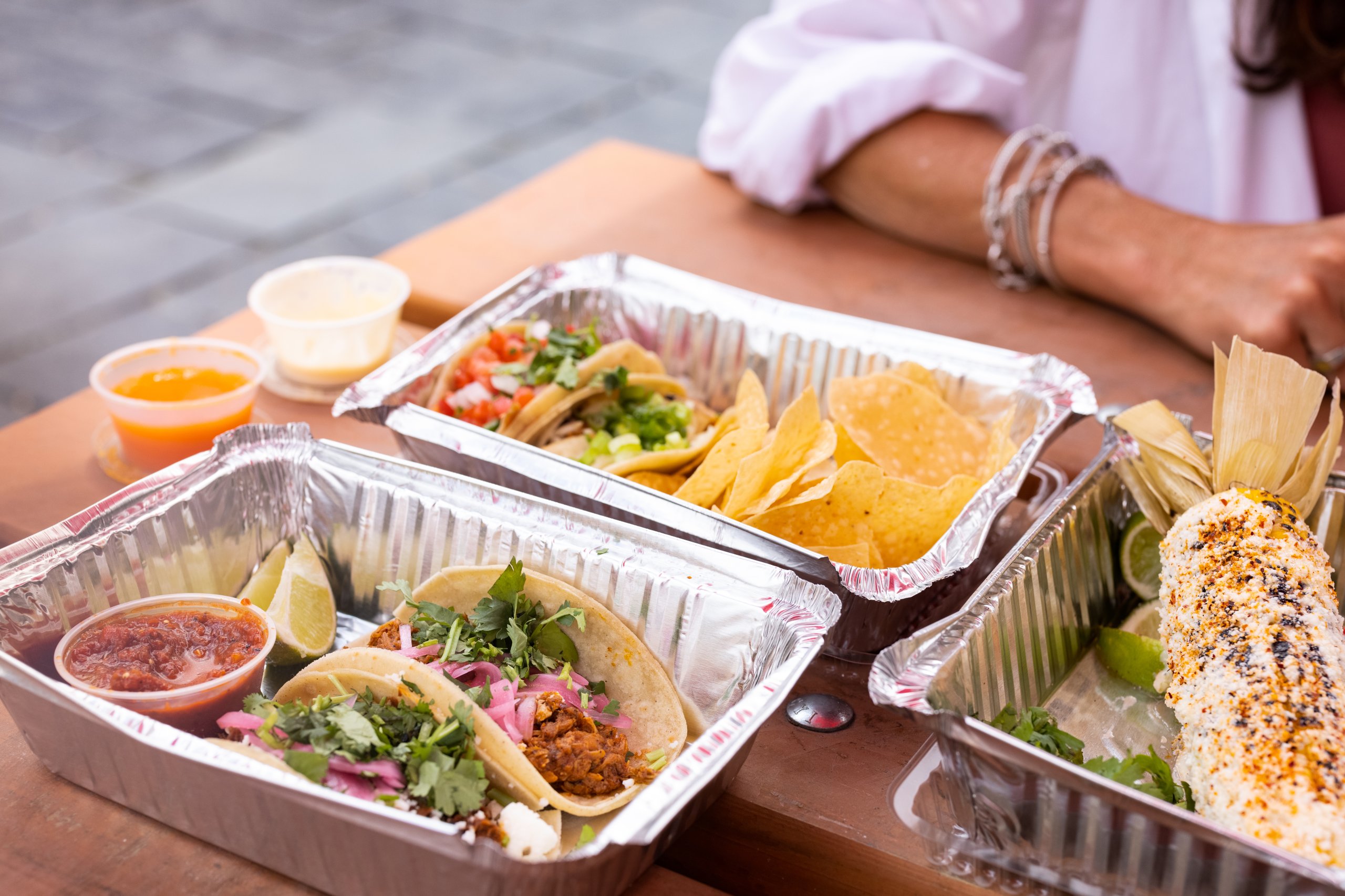 Full Trays Of Food Show Off Mouthwatering Tacos With Salsa And Lime, Chips And Dips, And Mexican Street Corn