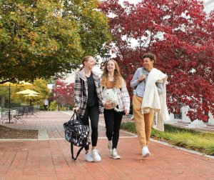 Three young women stroll along a brick walkway at Mary Baldwin University, enjoying their time together outdoors