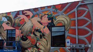 A vibrant mural of a Hispanic woman surrounded by a large flower, celebrating culture during Hispanic Heritage Month
