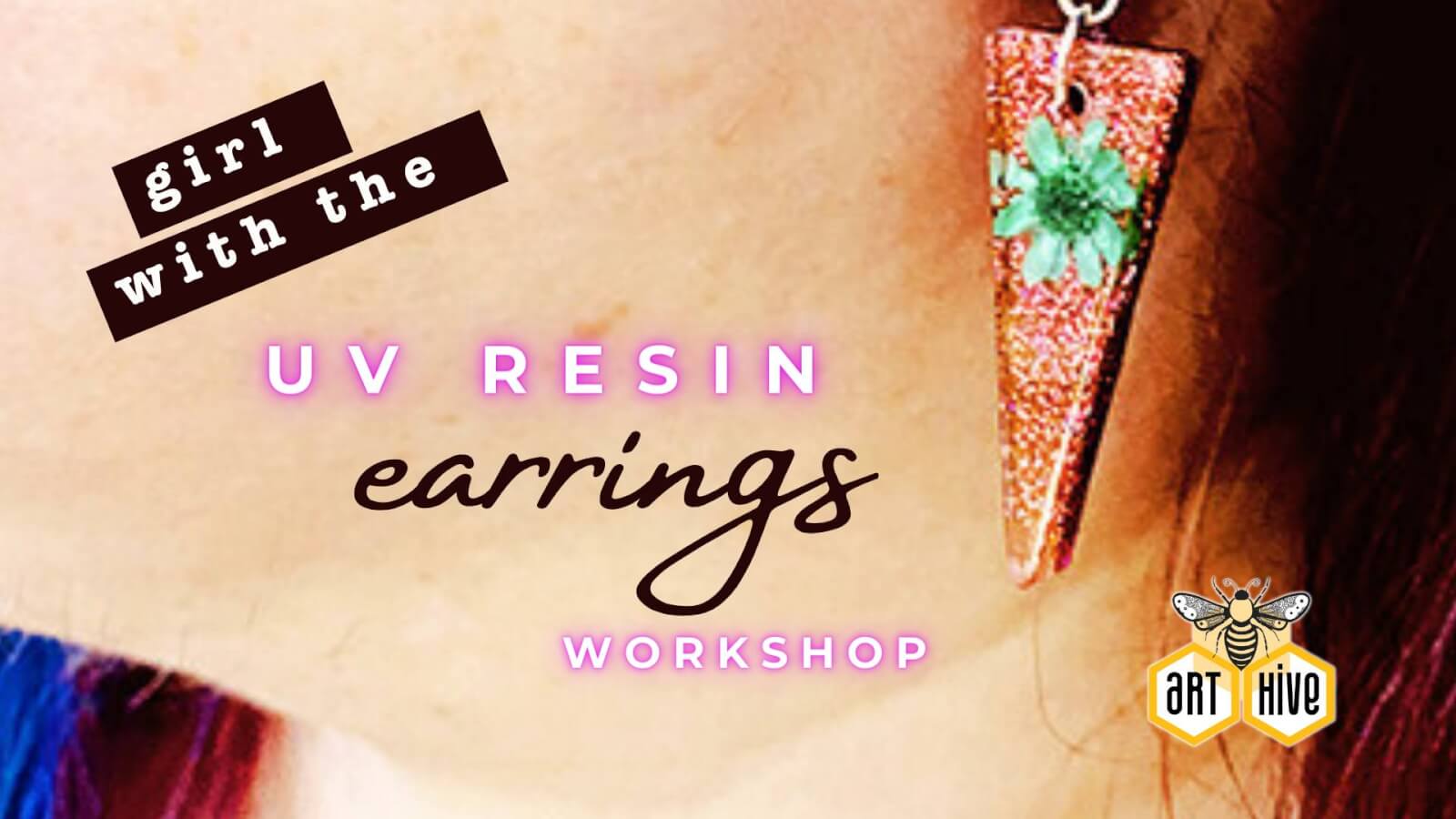 A woman proudly displays her handmade uv resin earrings during a workshop, celebrating her creativity and craftsmanship