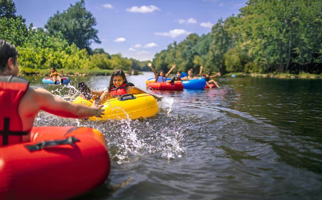 Family laughs and splashes while tubing on the James River