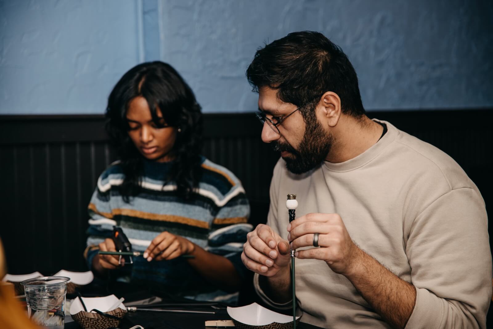 Man and woman build wands for team building activity
