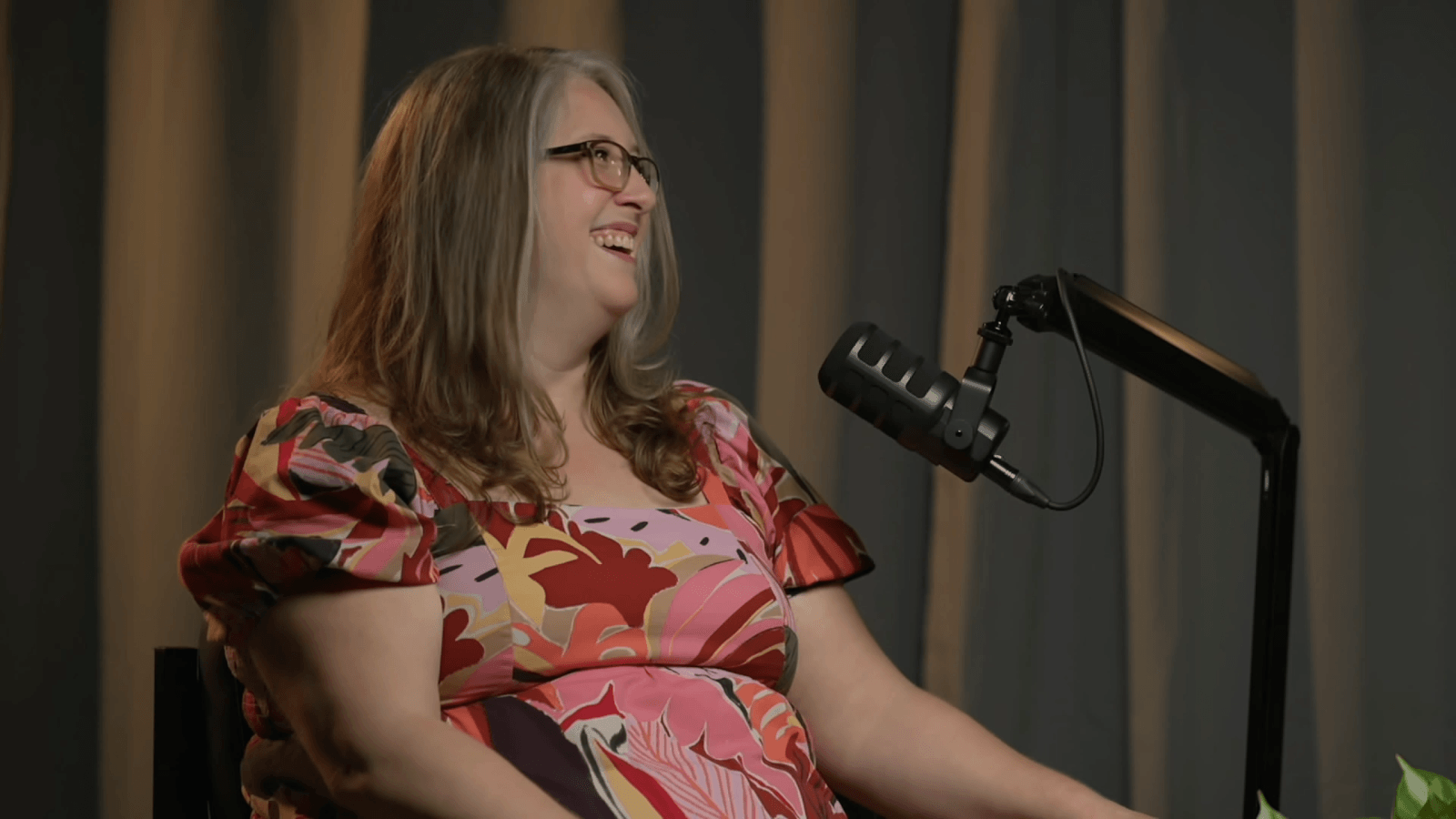 Molly smiles while speaking into microphone