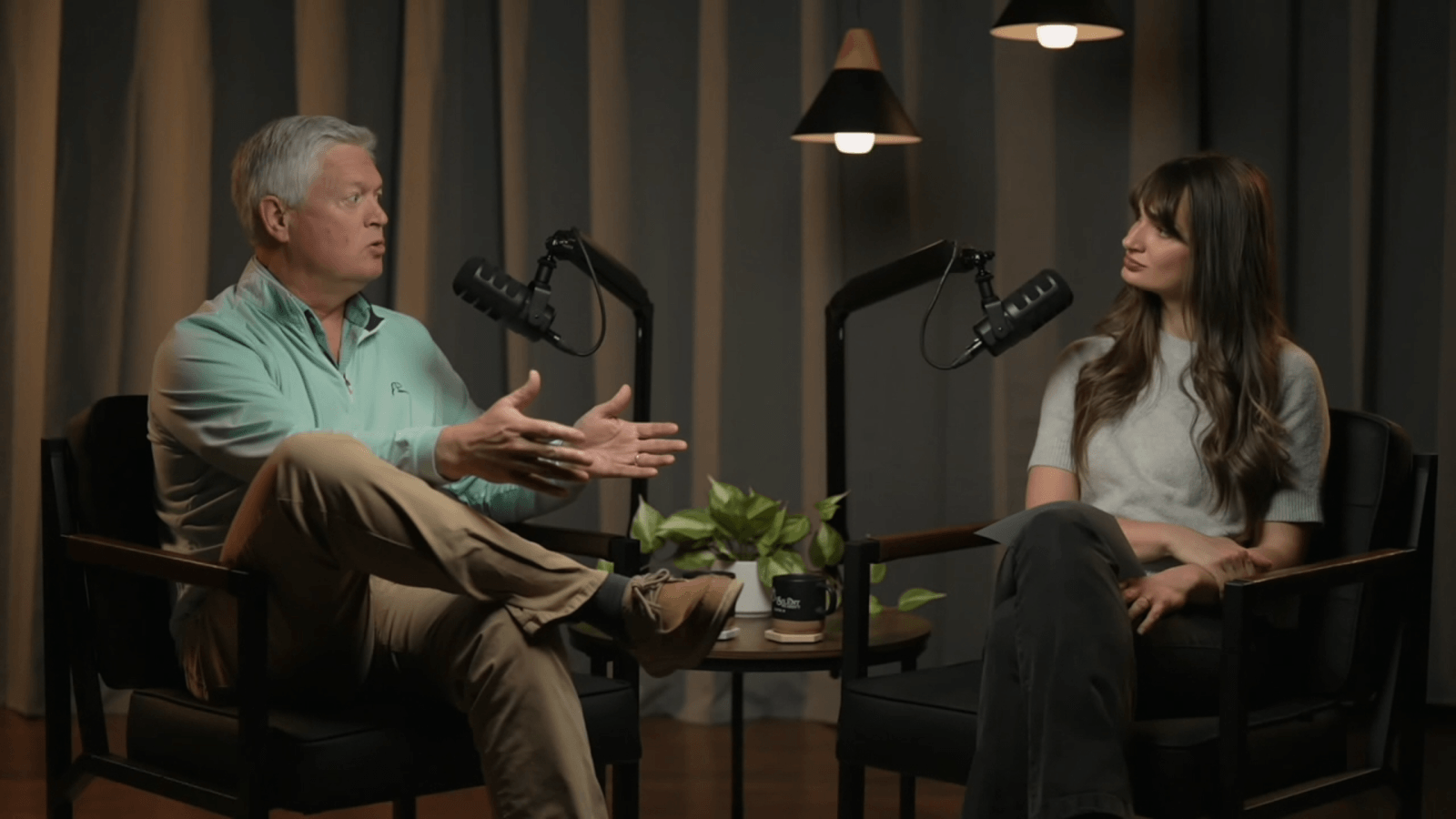 Butch Smiley and Samantha Johnson sit in chairs speaking toward each other in mics